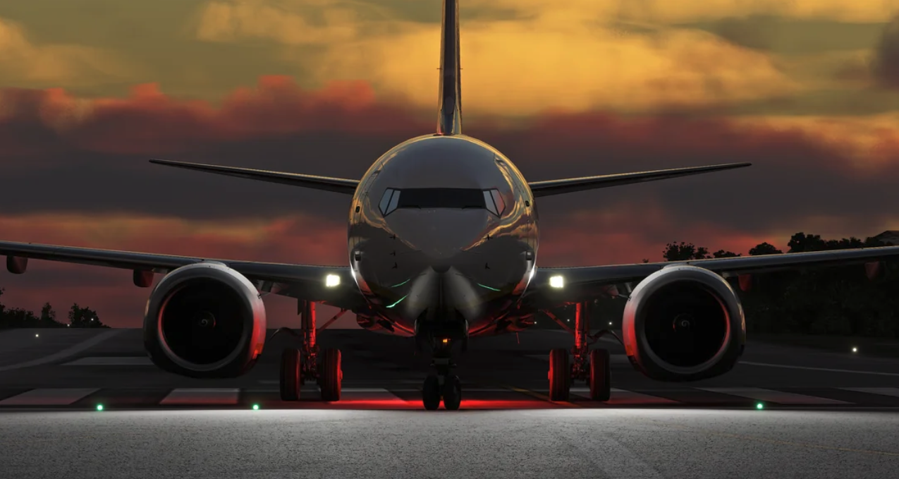 Commercial jet on the runway at dusk with landing lights on