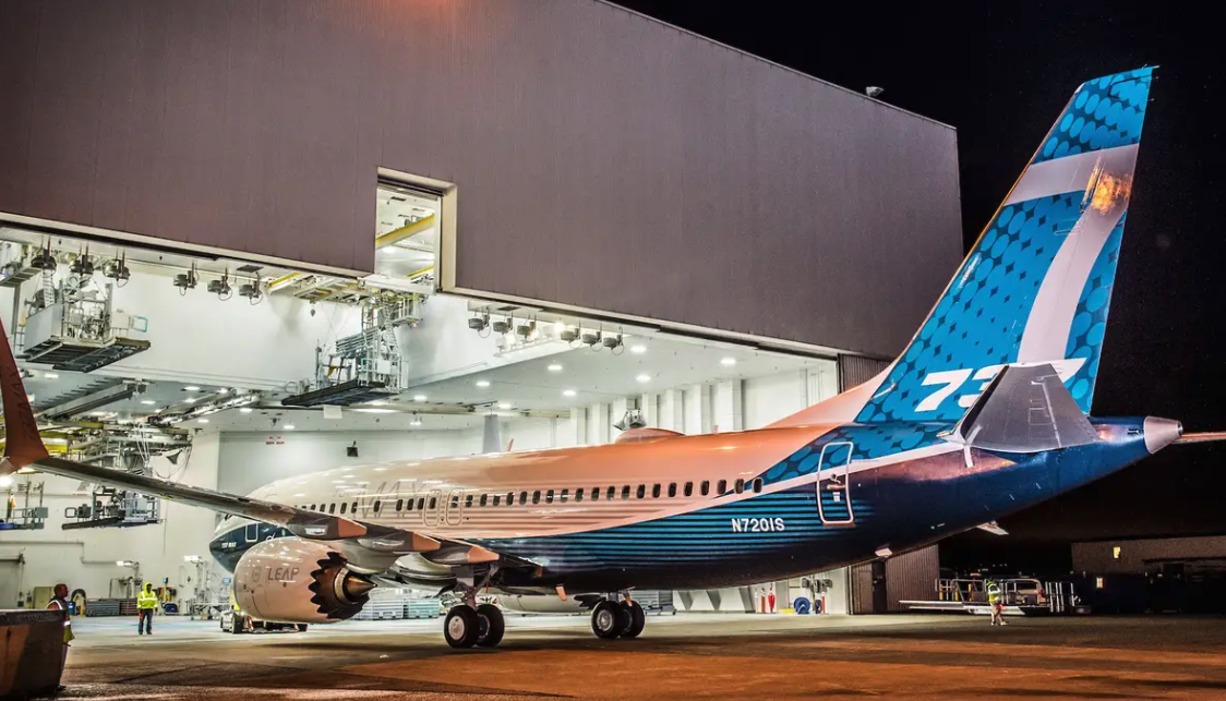 Boeing 737 in a brightly lit hangar at night